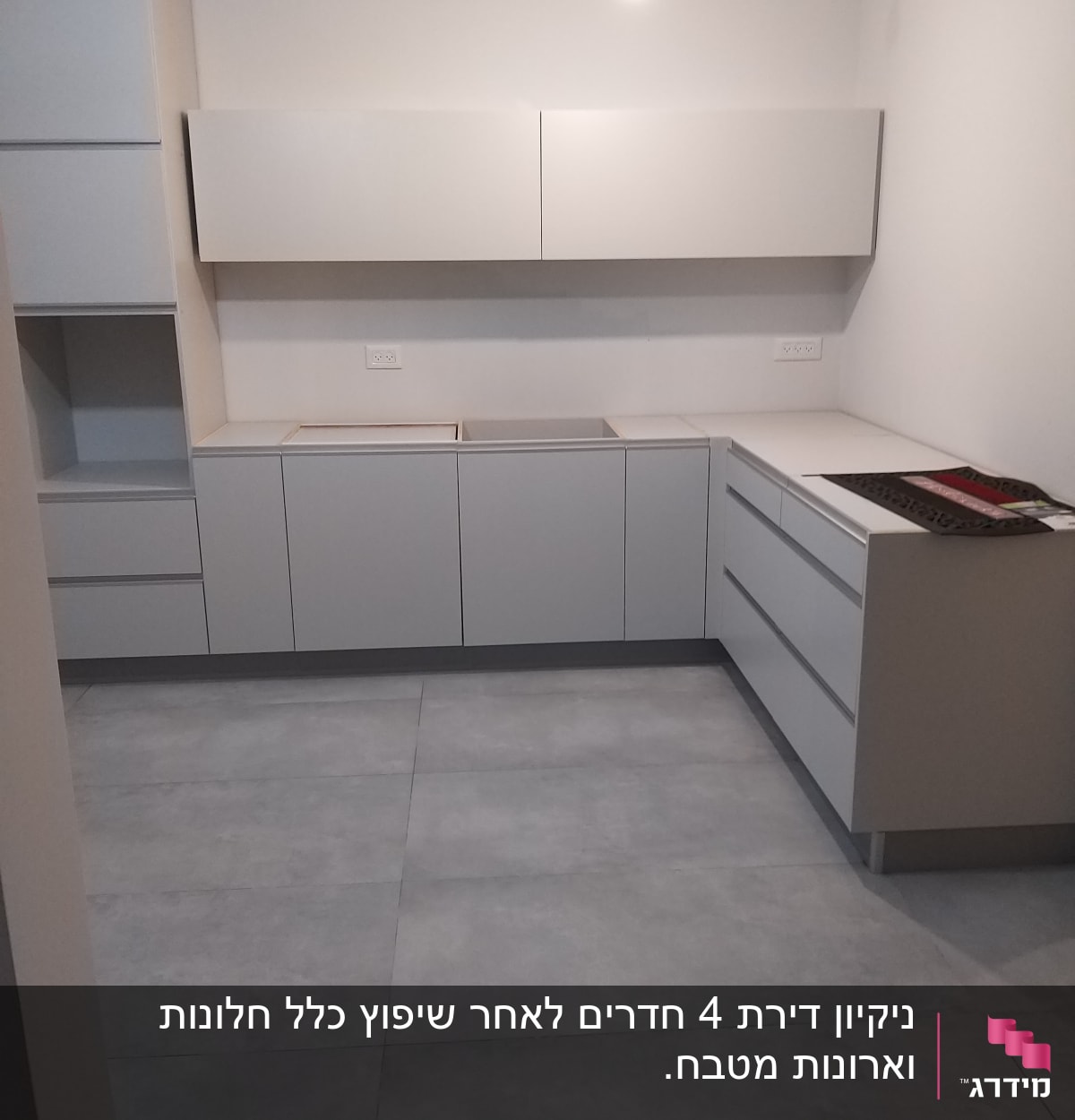 מטבח ריק עם ארונות ומשטחי עבודה נקיים